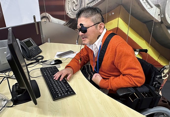 an image about An employee working while seated in an electric wheelchair